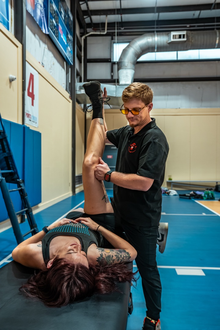 Trey performing an assisted hamstring stretch on a client