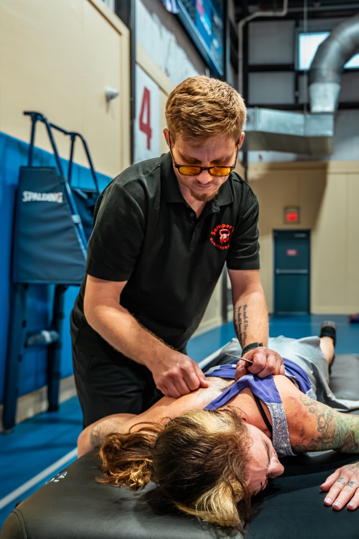 Trey performing IASTM body scraping on a roller derby athlete