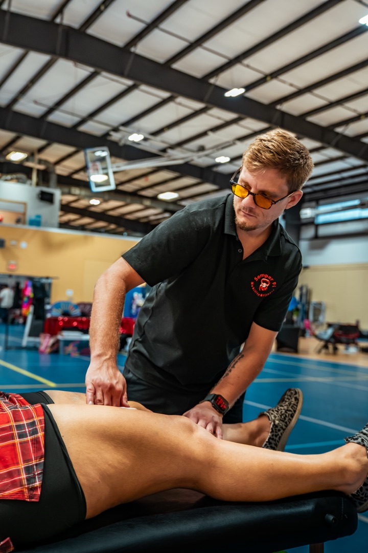 Trey performing assisted leg stretching on a roller derby athlete
